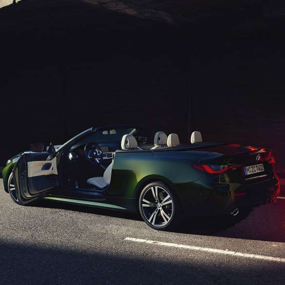 Three-quarter rear side view BMW 4 Series Convertible G23 2020 open door BMW 4 Series Convertible G23 2020 San Remo Green metallic three-quarter rear view with open passenger door