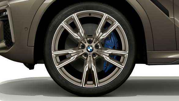 BMW X6 M50i SUV with focus on light alloy wheel. BMW X6 M50i SUV exterior with focus on light alloy wheel.