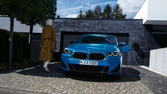 Plug-in hybrid BMW X2 xDrive25e F39 front view in front of garage Plug-in hybrid BMW X2 xDrive25e F39 front view in front of garage with model