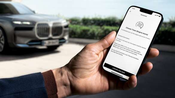 Remote Engine Start BMW bookable add-on functions BMW bookable add-on functions Remote Engine Start smartphone in hand with BMW vehicles in background