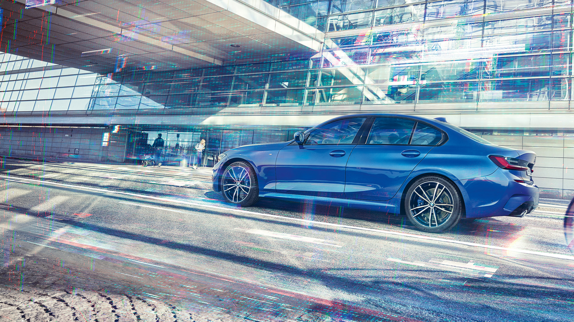 BMW 3 Series Saloon, side view. Still shot of the BMW 3 Series Saloon from the side on the day in front of a glass building.