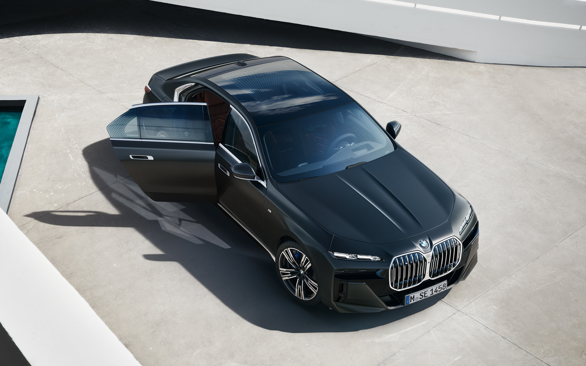 BMW 7 Series Saloon G70 ICE 740i M sports package Frozen Deep Grey metallic bird's eye view with open passenger door