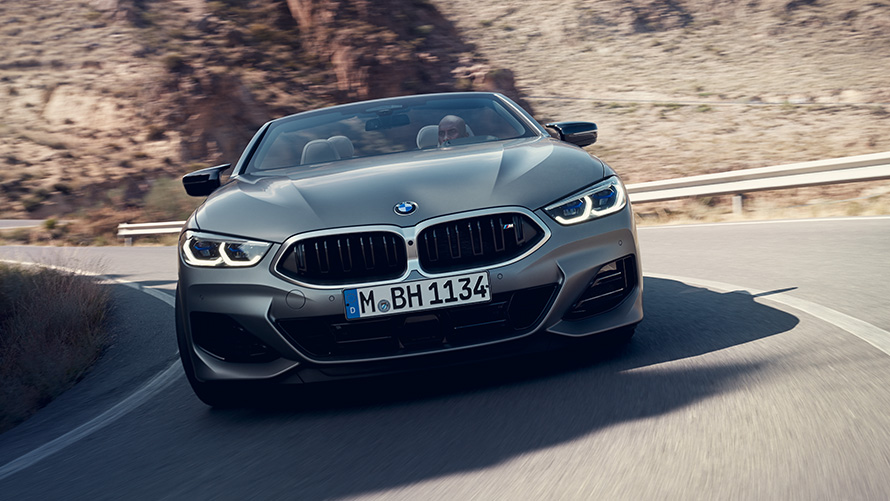 BMW 8 Series Convertible M sport package G14 LCI Facelift 2022 front view driving through corner BMW 8 Series Convertible M sport package G14 LCI Facelift 2022 BMW Individual Frozen Pure Grey metallic front view driving through corner