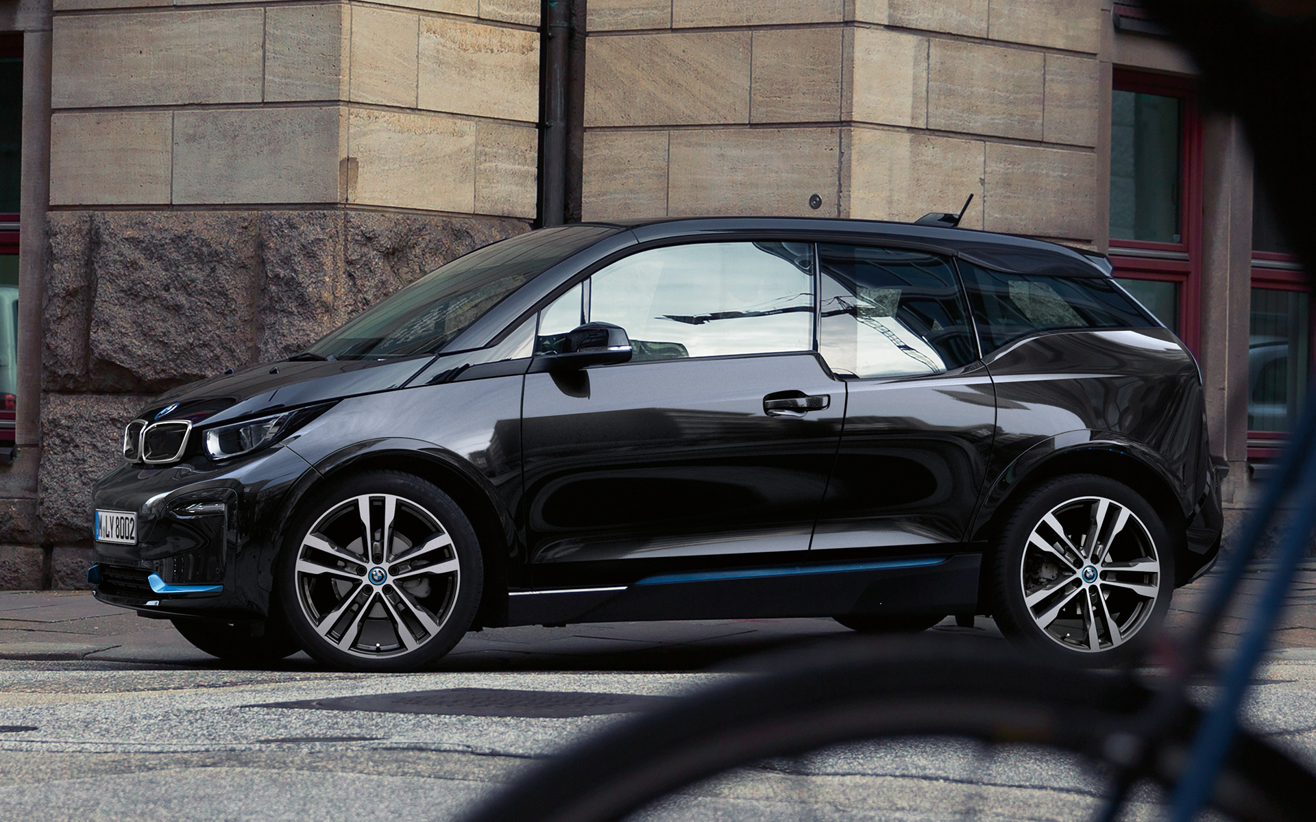BMW i3s I01 2018 Fluid Black with BMW i Blue highlight side view in urban setting driving