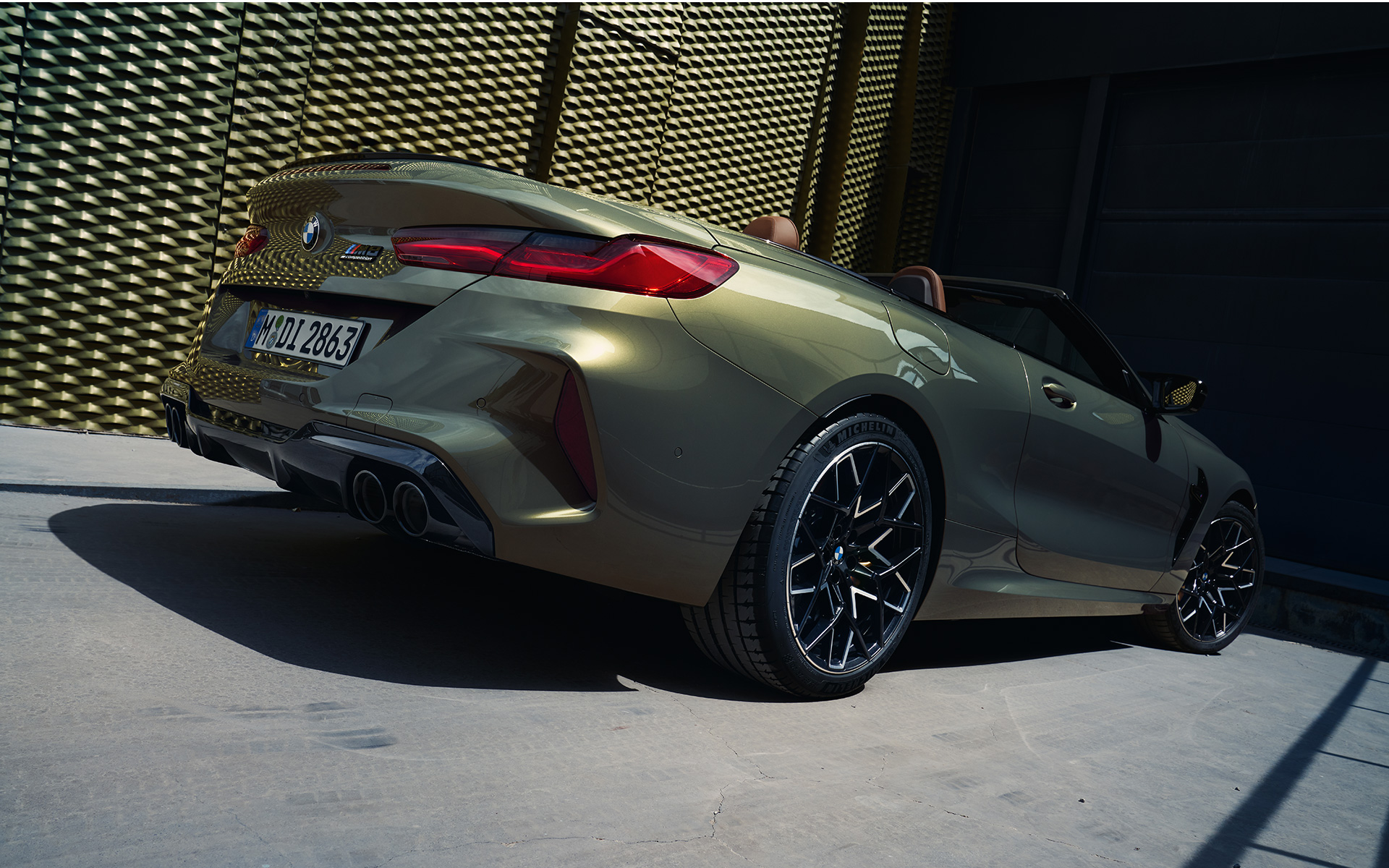 Three-quarter rear view BMW M8 Competition Convertible F91 LCI Facelift 2022 BMW M8 Competition Convertible F91 LCI Facelift 2022 BMW Individual Brass metallic three-quarter rear view low angle shot
