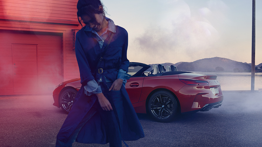 BMW Z4 M40i Roadster G29 with open soft-top BMW Z4 M40i Roadster G29 three-quarter rear view with open soft-top and woman in the foreground