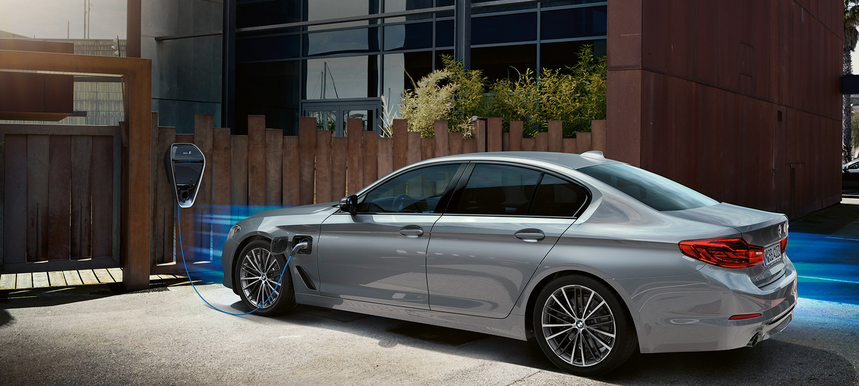 BMW 530e at charging station. BMW 530e in three-quarter at charging station.