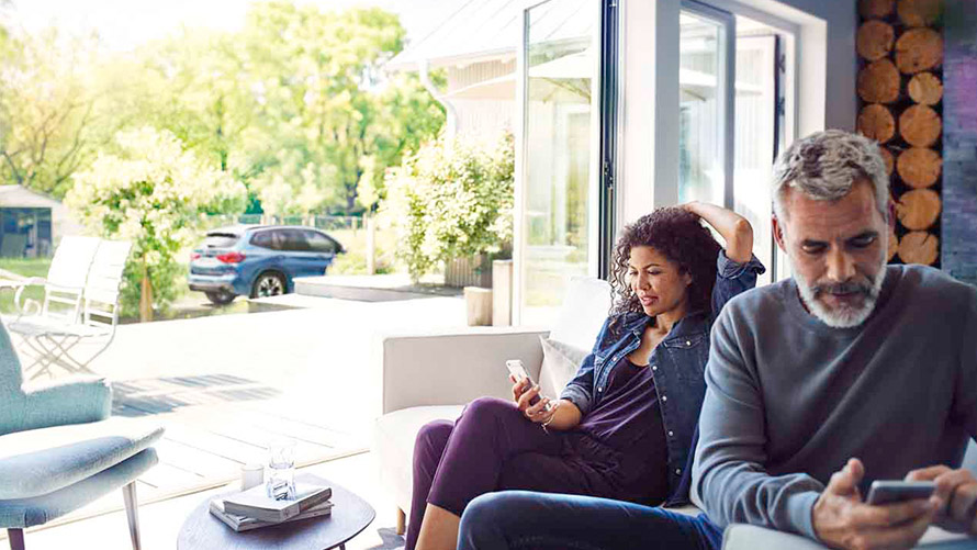 Remote Services Man and woman sitting on sofa and using Remote Services on their smartphones