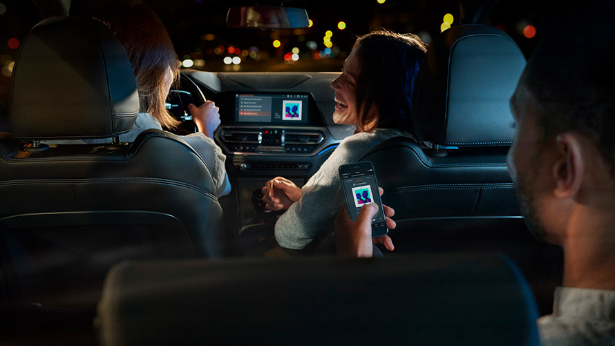 Connected Command Connected Command: Three people in BMW playing music while making a trip