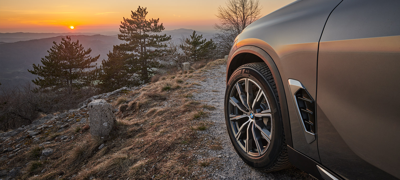 Original BMW Wheels on the BMW X5 (G05 LCI) Original BMW Wheels on the BMW X5 (G05 LCI) on a dirt road at a mountainside, facing the sunset