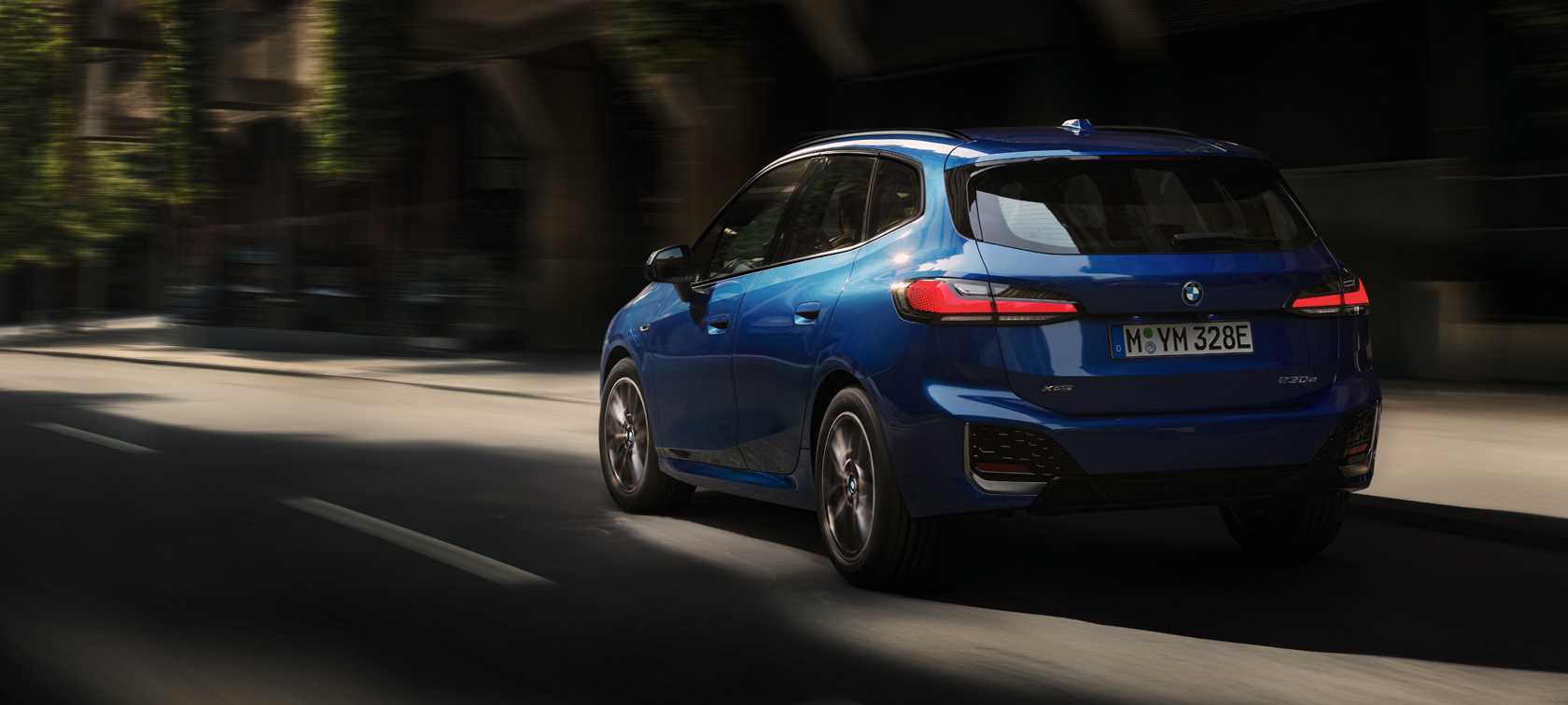 BMW 2 Series Active Tourer 230e plug-in hybrid U06 2021 M Portimao Blue metallic three-quarter rear view driving in the city