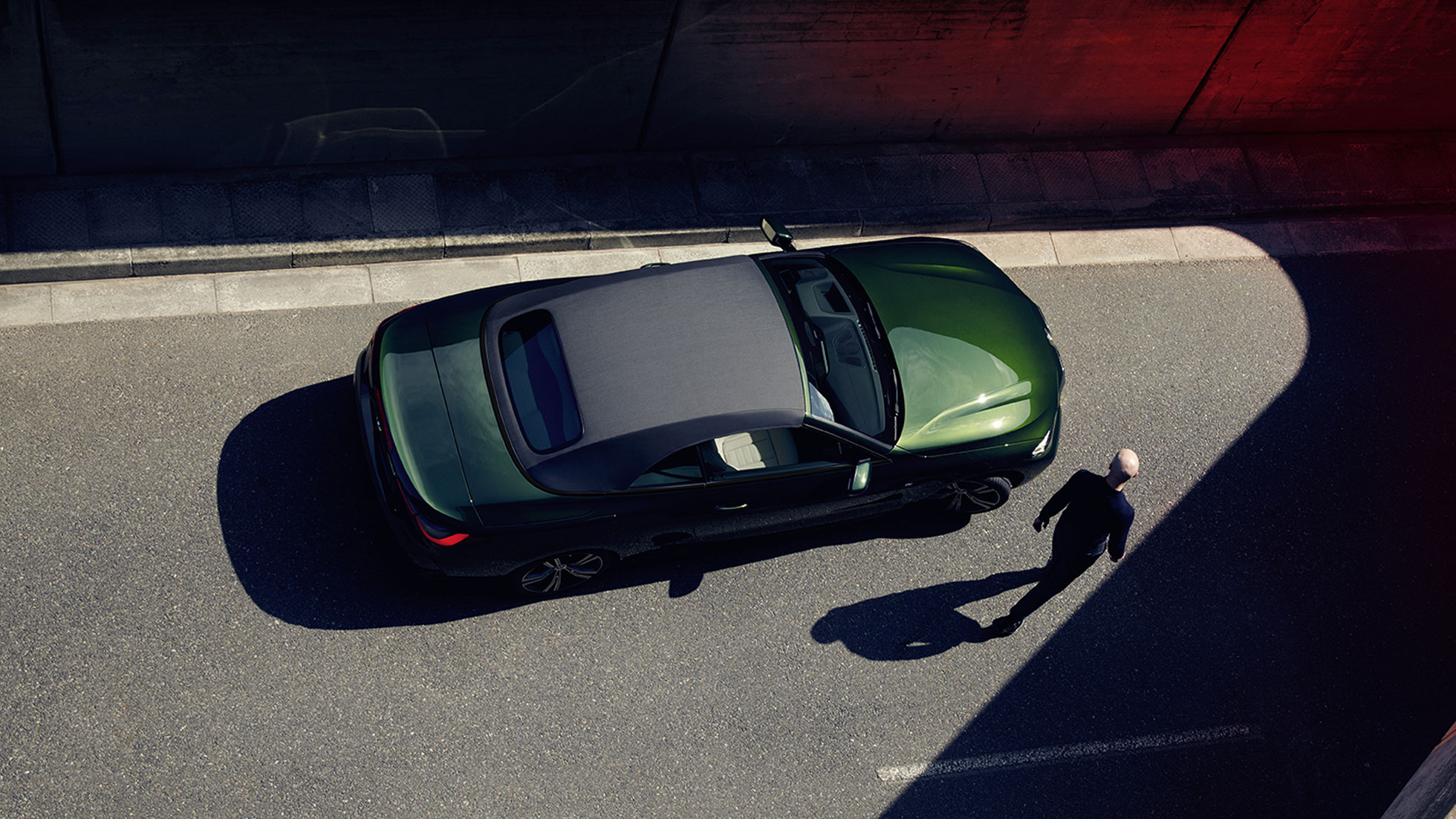 Bird's-eye view soft top BMW 4 Series Convertible G23 2020 with a man BMW 4 Series Convertible G23 2020 San Remo Green metallic bird's-eye view soft top with a man walking next to it